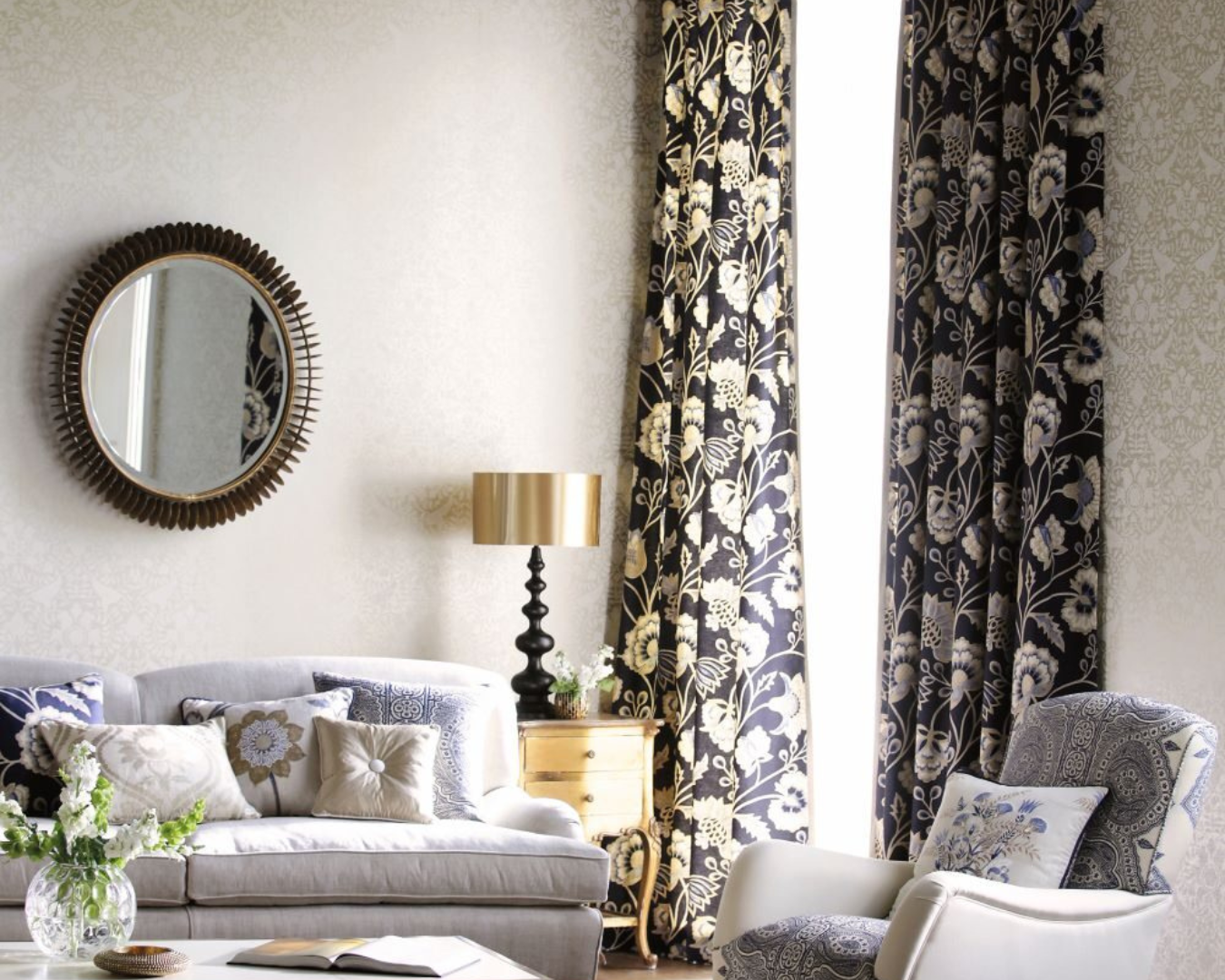 Beautiful, modern living room with dark, floral drapes hanging up.